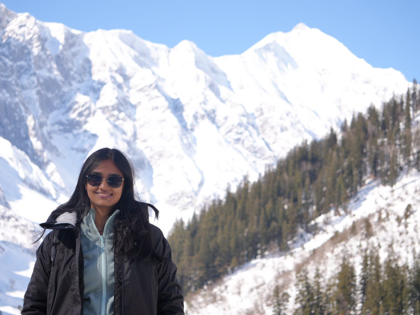 Insha standing in front of snow-covered mountains